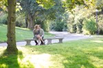 Bri and Ryan kissing on a park bench.